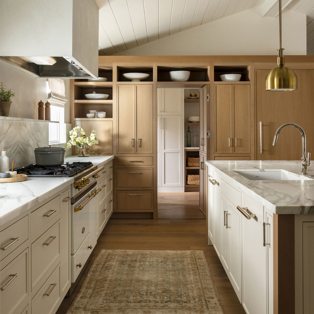 a kitchen with white cabinets and wooden floors