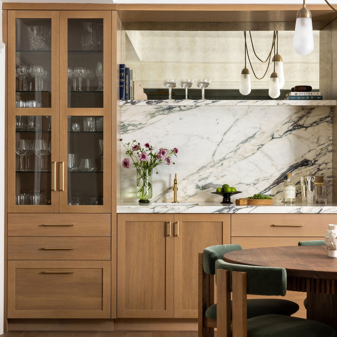 a kitchen with a marble counter top and wooden cabinets