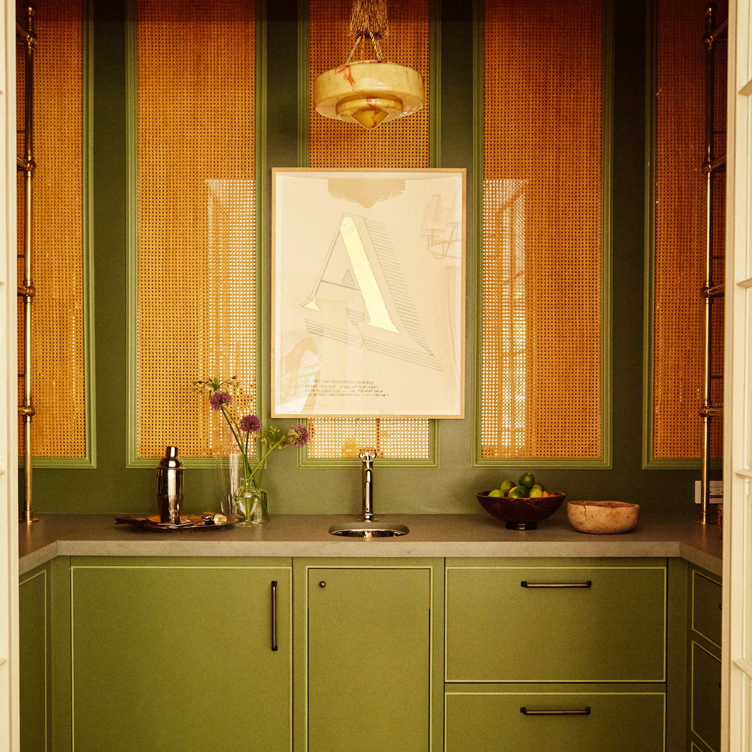 a kitchen with green cabinets and wooden floors