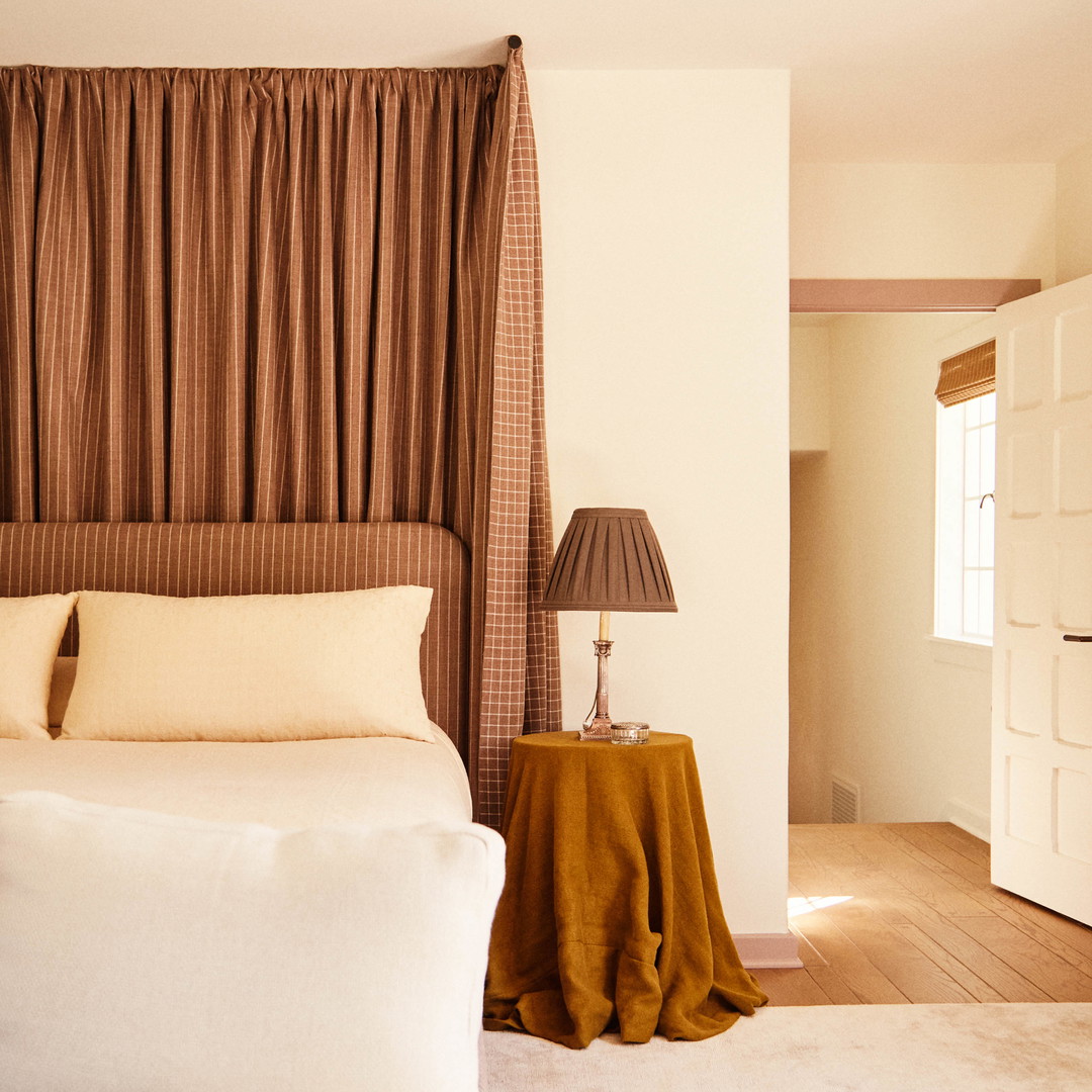 a bed sitting in a bedroom next to a lamp