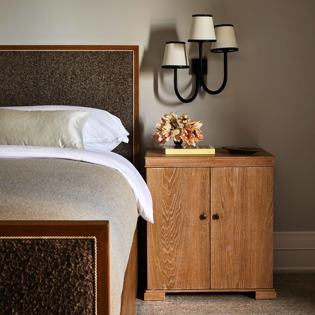 a bedroom with a bed, nightstand and two lamps