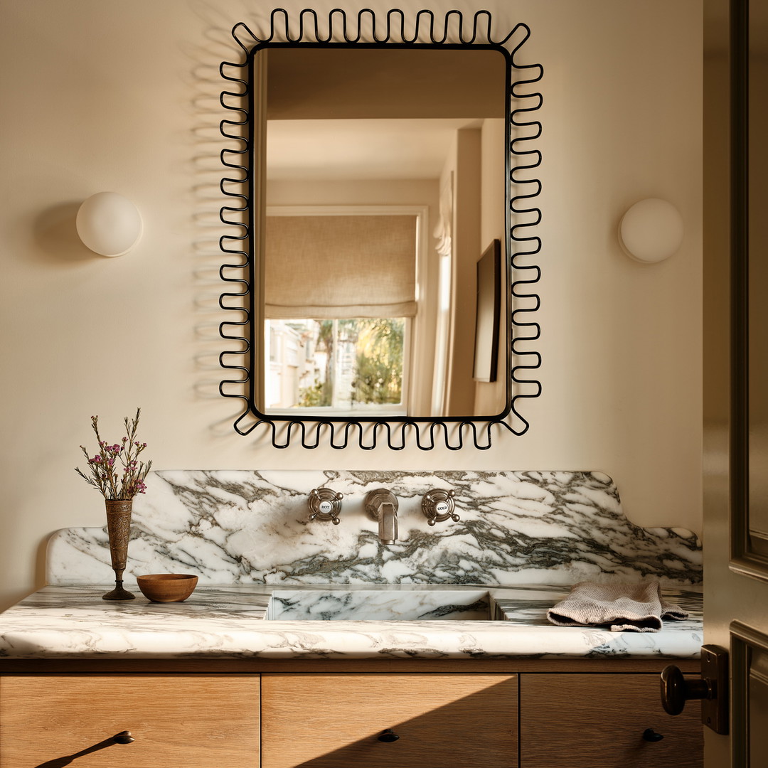 a bathroom with a marble counter top and a large mirror