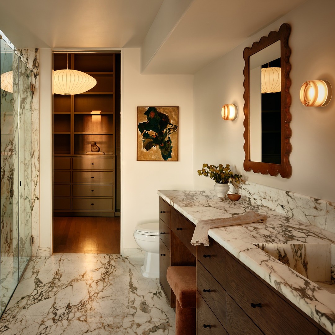 a bathroom with a marble counter top and a walk in shower