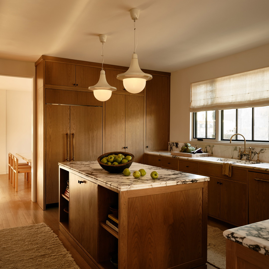 a kitchen with a center island with a bowl of fruit on it