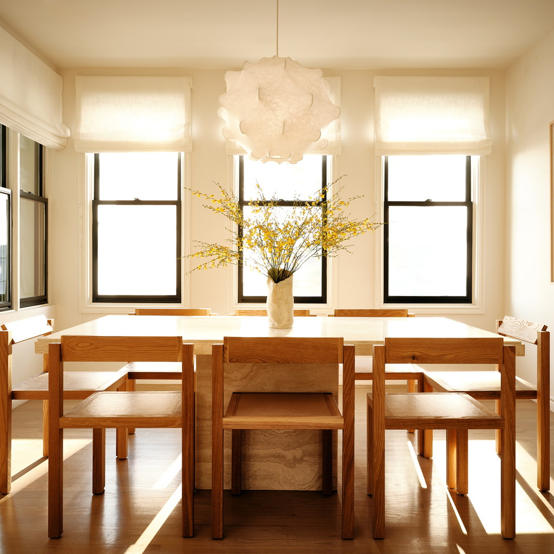 a dining room table with a vase of flowers on top of it