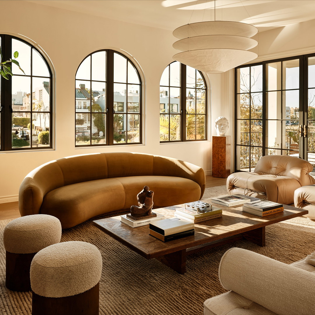 a living room filled with furniture and large windows