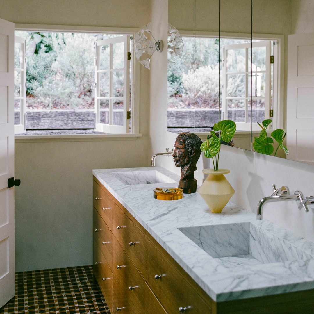 a bathroom with a sink, mirror and a window