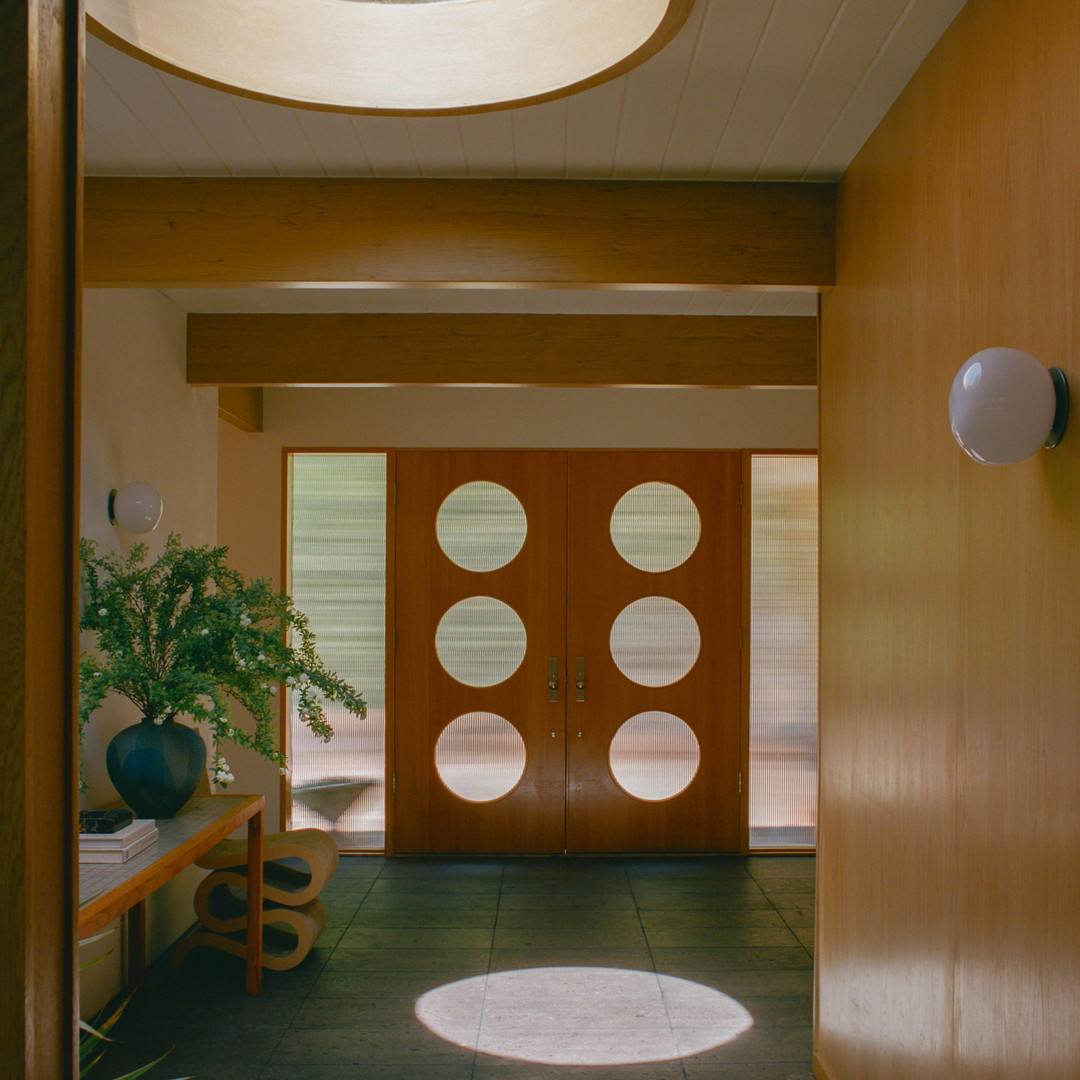a hallway with a door and a potted plant