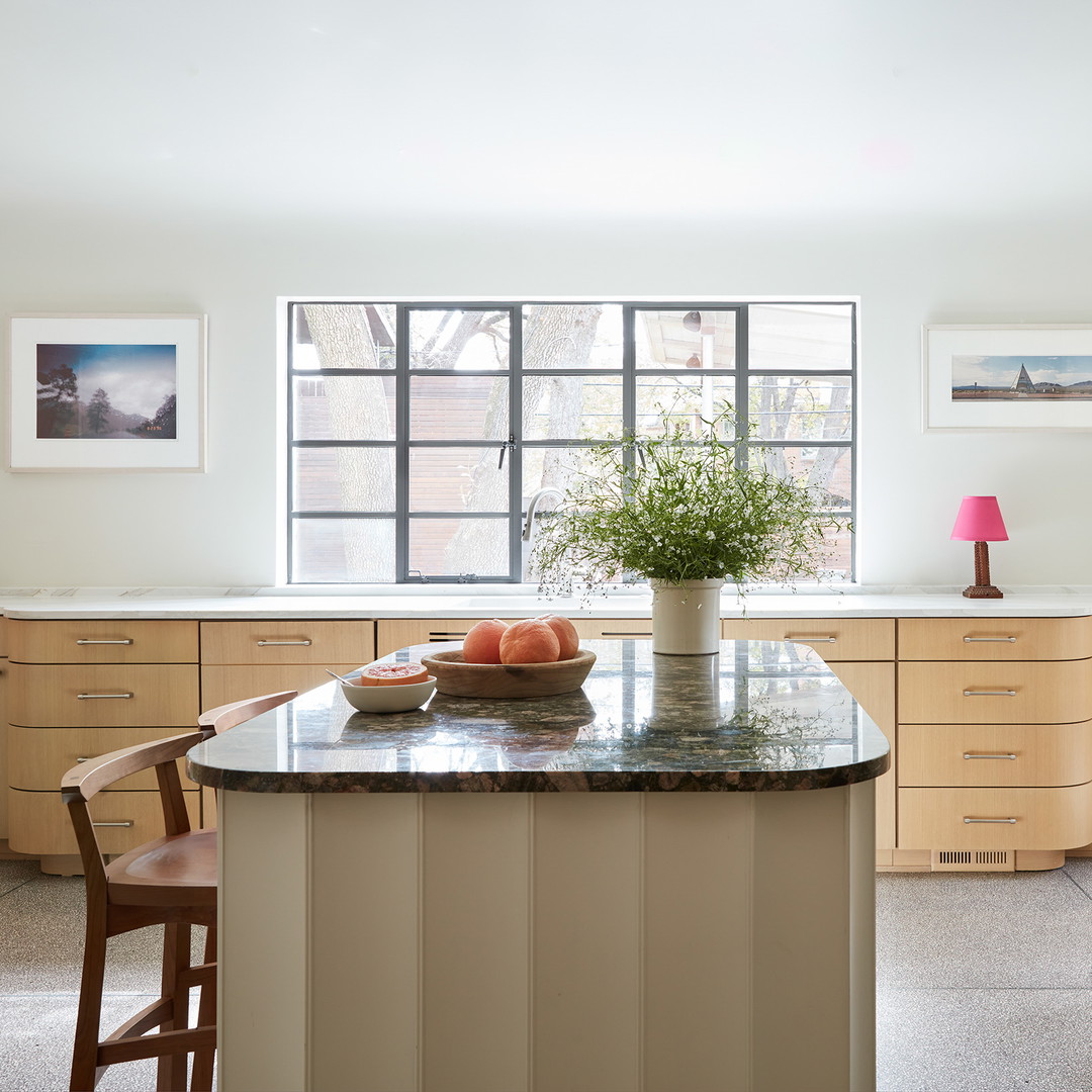 a kitchen with a center island with a bowl of fruit on it