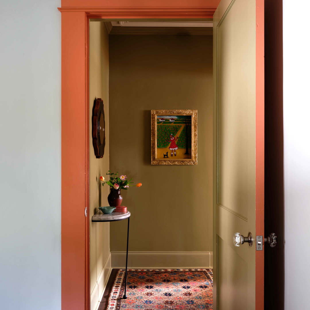 a hallway with a painting on the wall and a rug on the floor