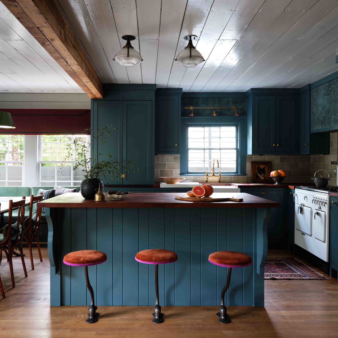 a kitchen with blue cabinets and wooden floors