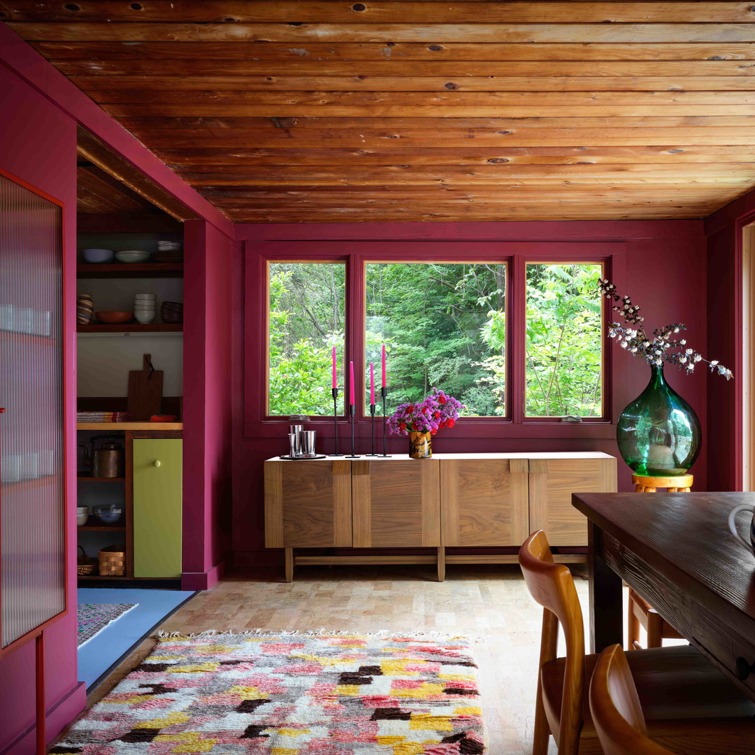 a dining room with a table and a vase of flowers