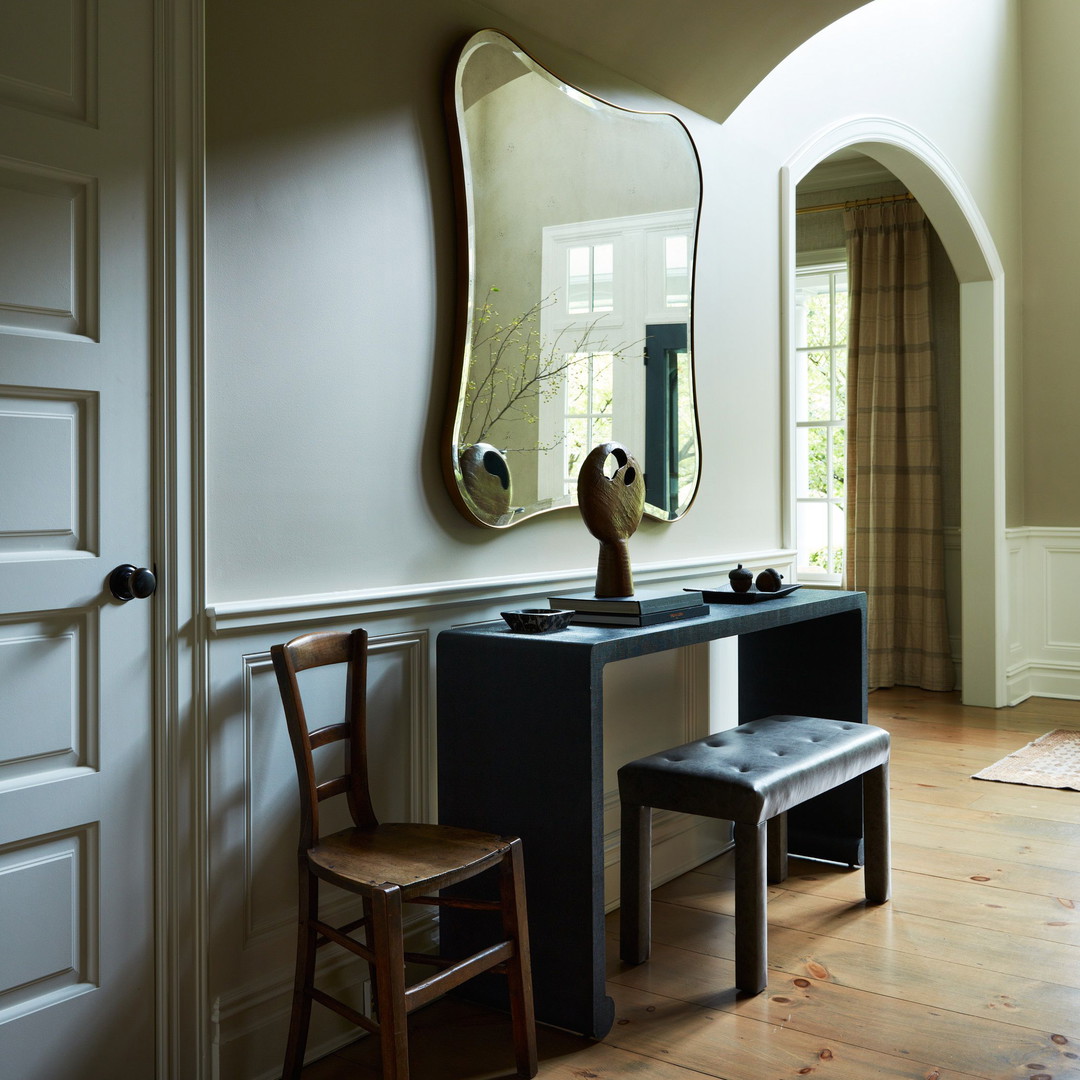 a room with a chair, mirror and a bench