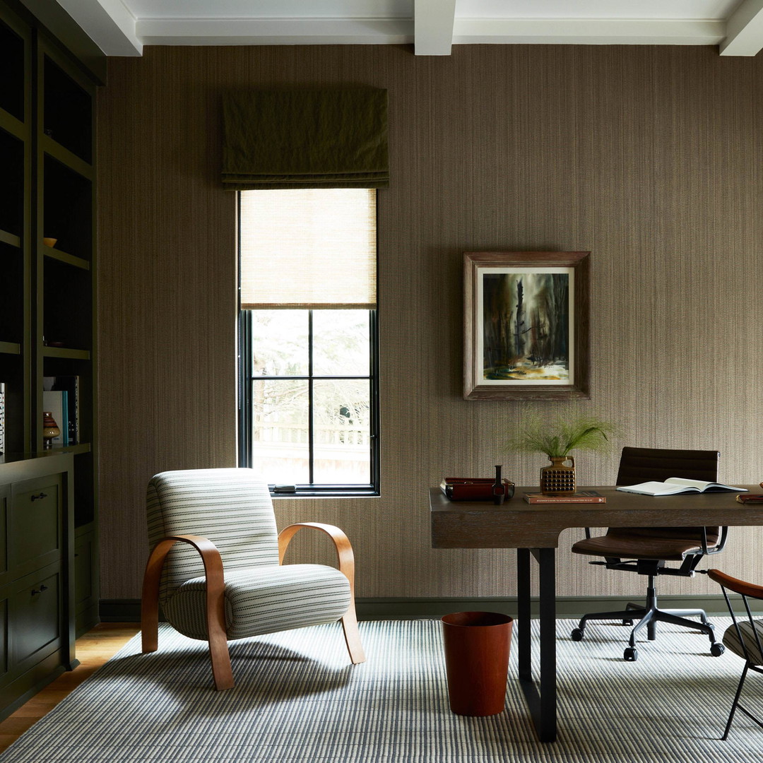 a room with a desk, chair, bookshelf and a lamp