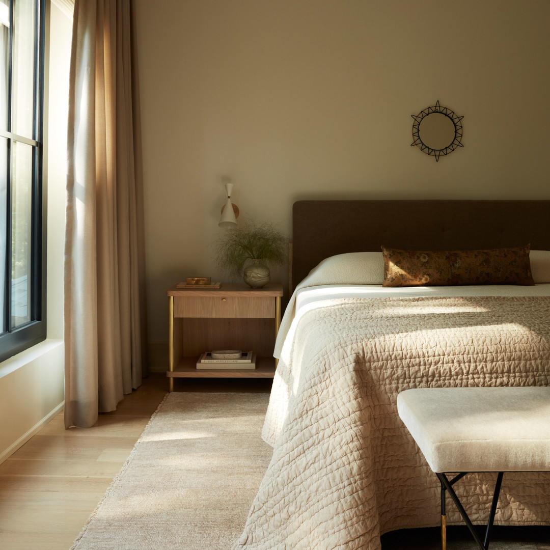 a bedroom with a bed and a bench in front of a window