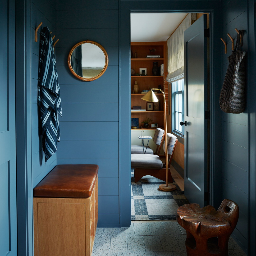 a blue hallway with a bench and mirror