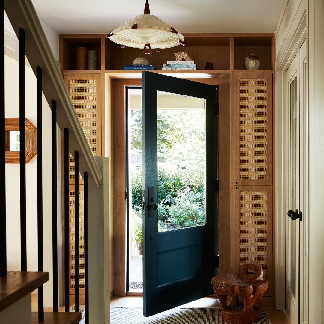 a hallway with a black door and wooden steps