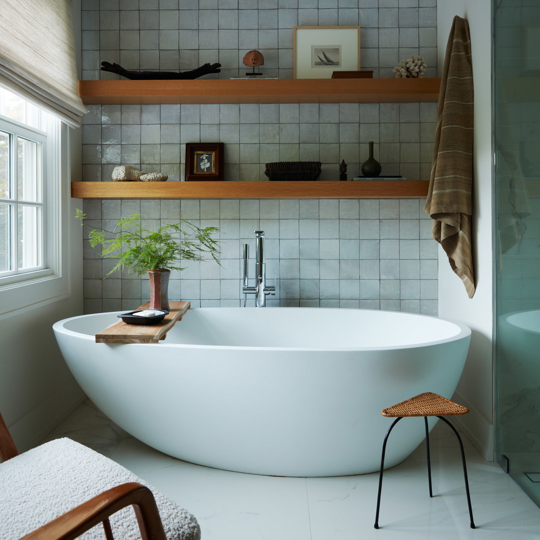 a bathtub in a bathroom with a plant in it