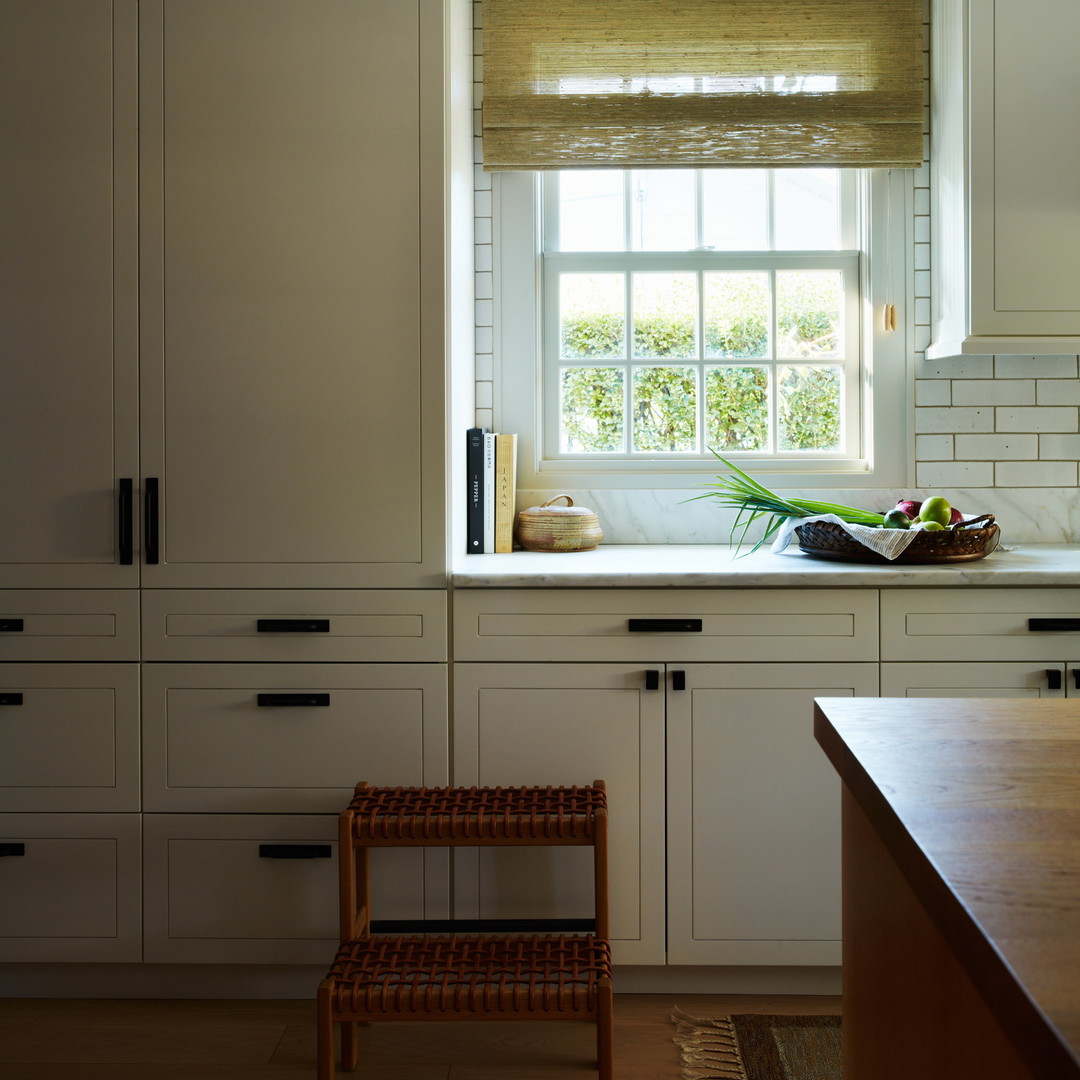 a kitchen with white cabinets and a window