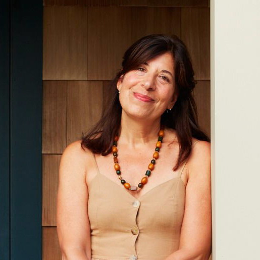 a woman standing on a porch next to a blue door