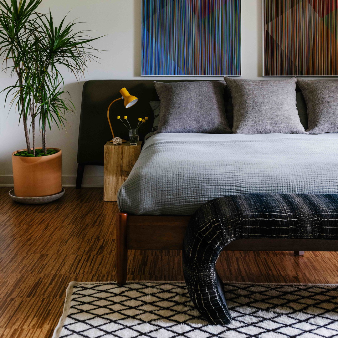 a bedroom with a large bed and paintings on the wall