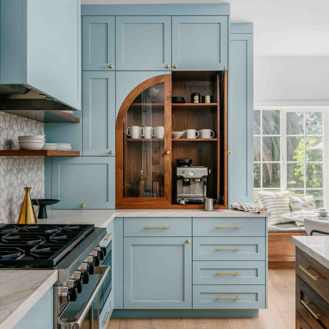 a kitchen with blue cabinets and wooden floors