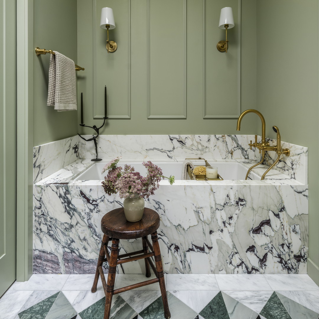 a bathroom with green walls and marble counter tops