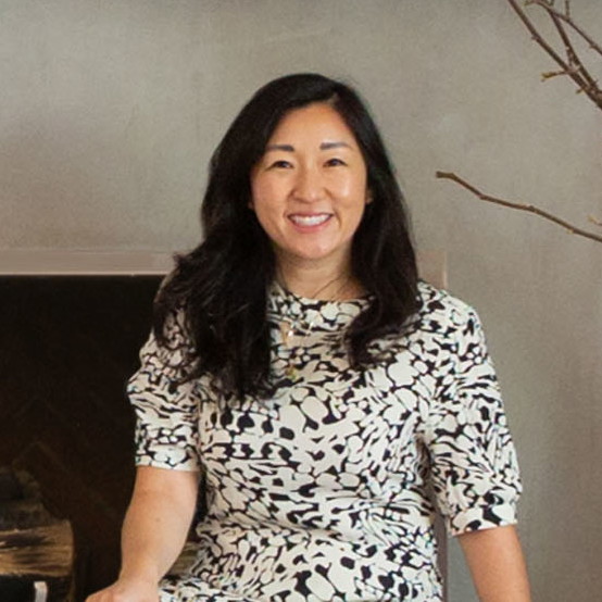 a woman sitting on a chair in front of a fireplace