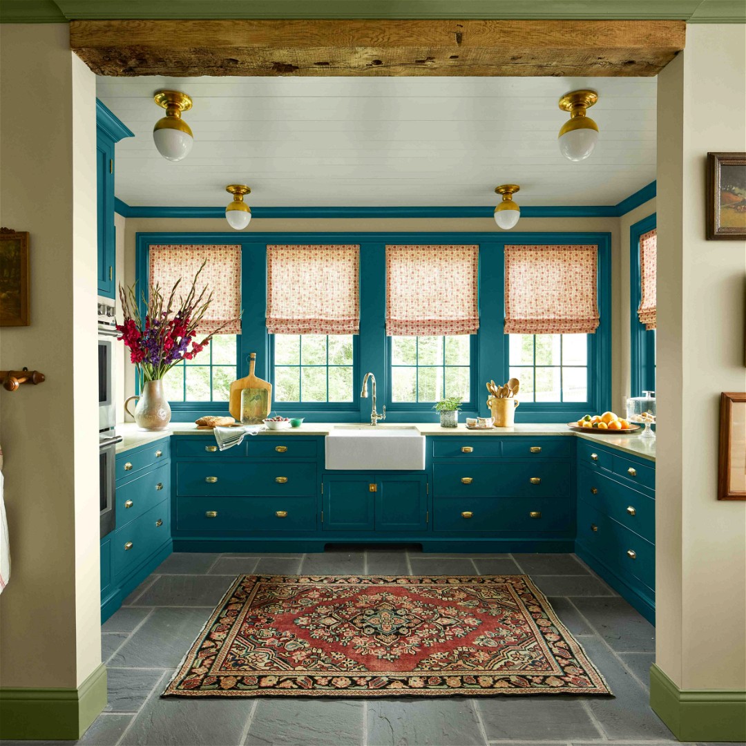 a bathroom with blue cabinets and a rug on the floor