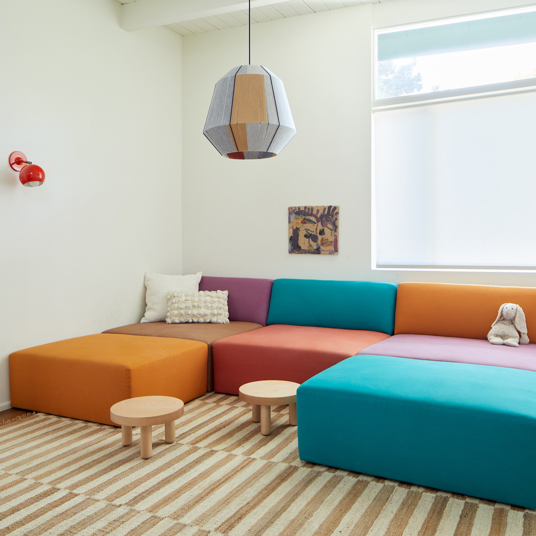 a living room with a colorful couch and ottoman