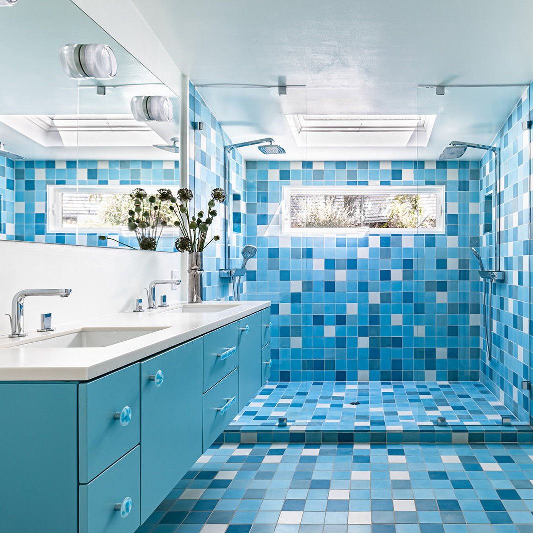 a bathroom with blue and white tiles on the walls