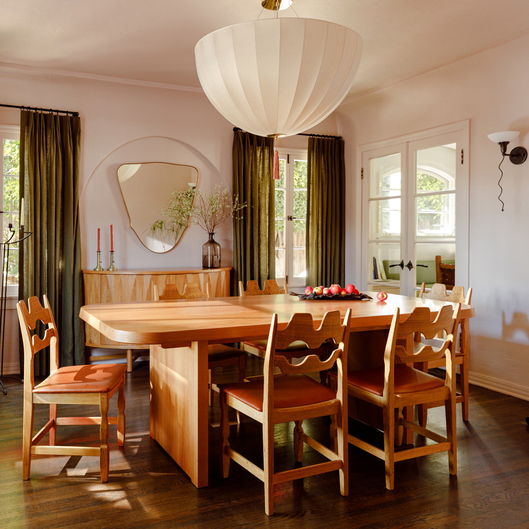 a dining room with a wooden table surrounded by chairs