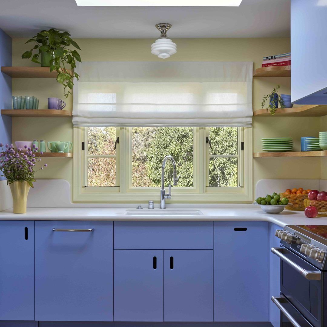 a kitchen with blue cabinets and white counter tops