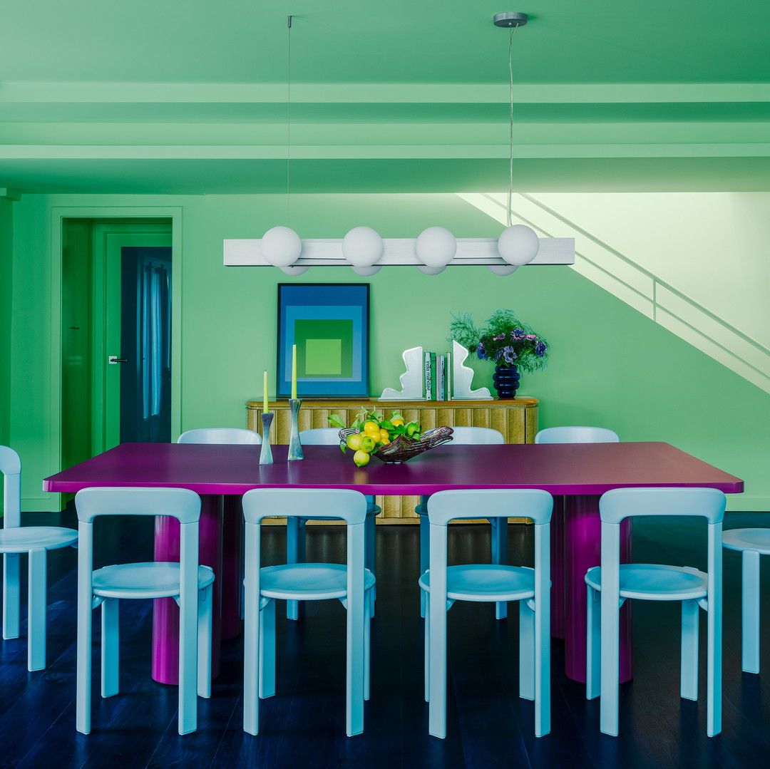 a dining room with a purple table surrounded by white chairs