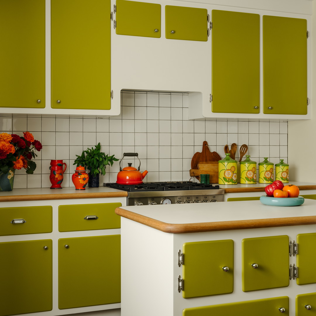 a kitchen with green cabinets and a white counter top