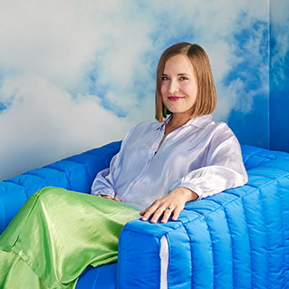 a woman sitting on a blue couch in a room