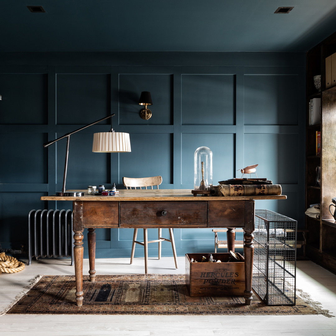 a room with blue walls and a wooden desk