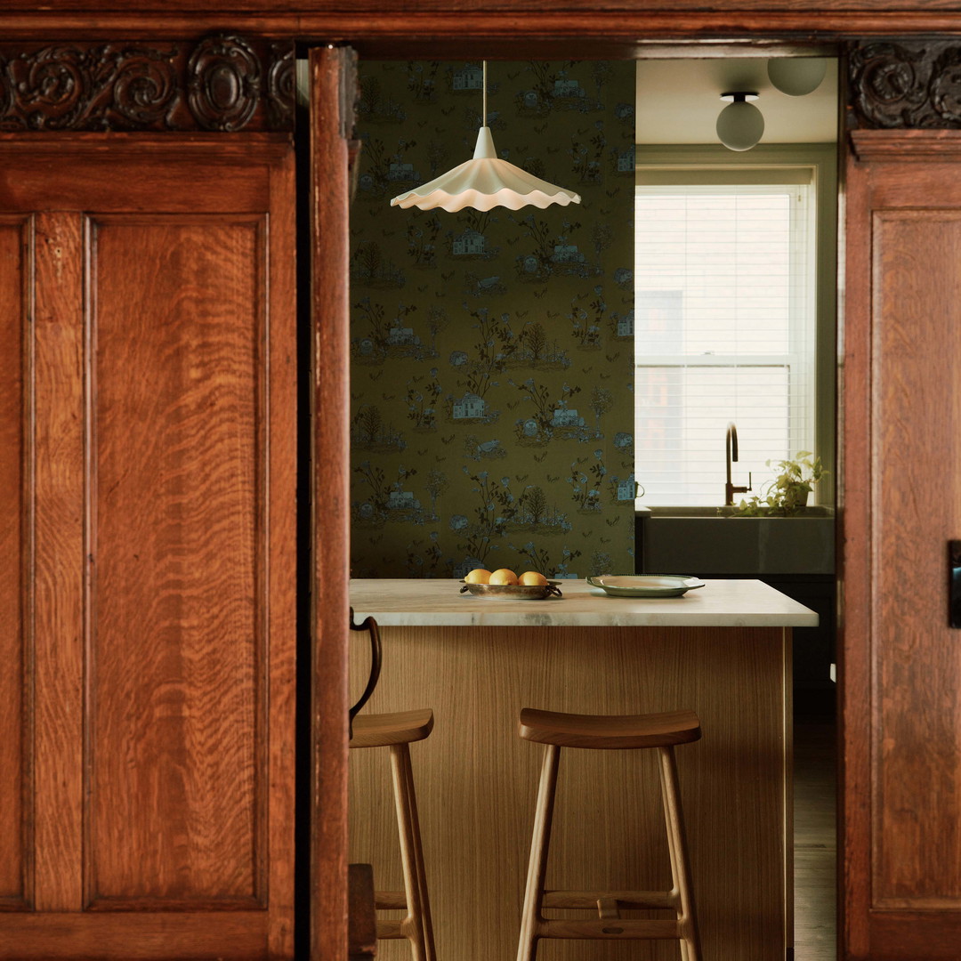 a kitchen with two stools in the middle of it