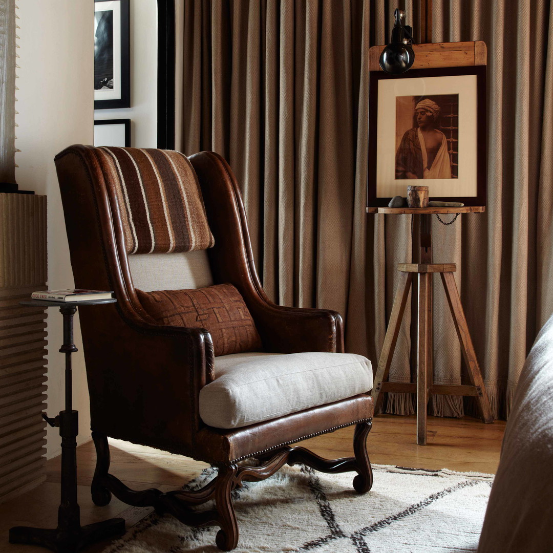 a living room with a chair and a picture on the wall