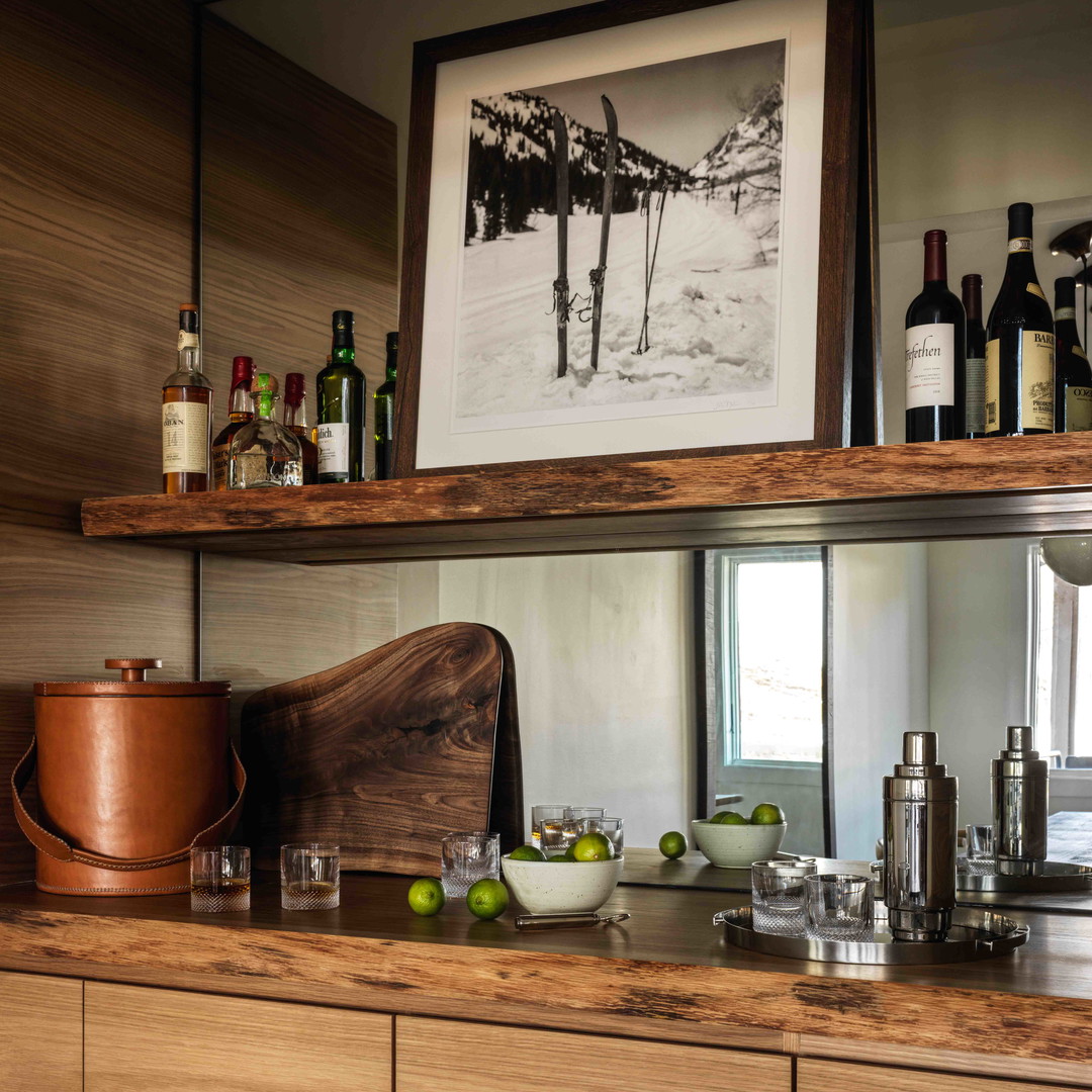 a kitchen counter with bottles of wine and glasses on it