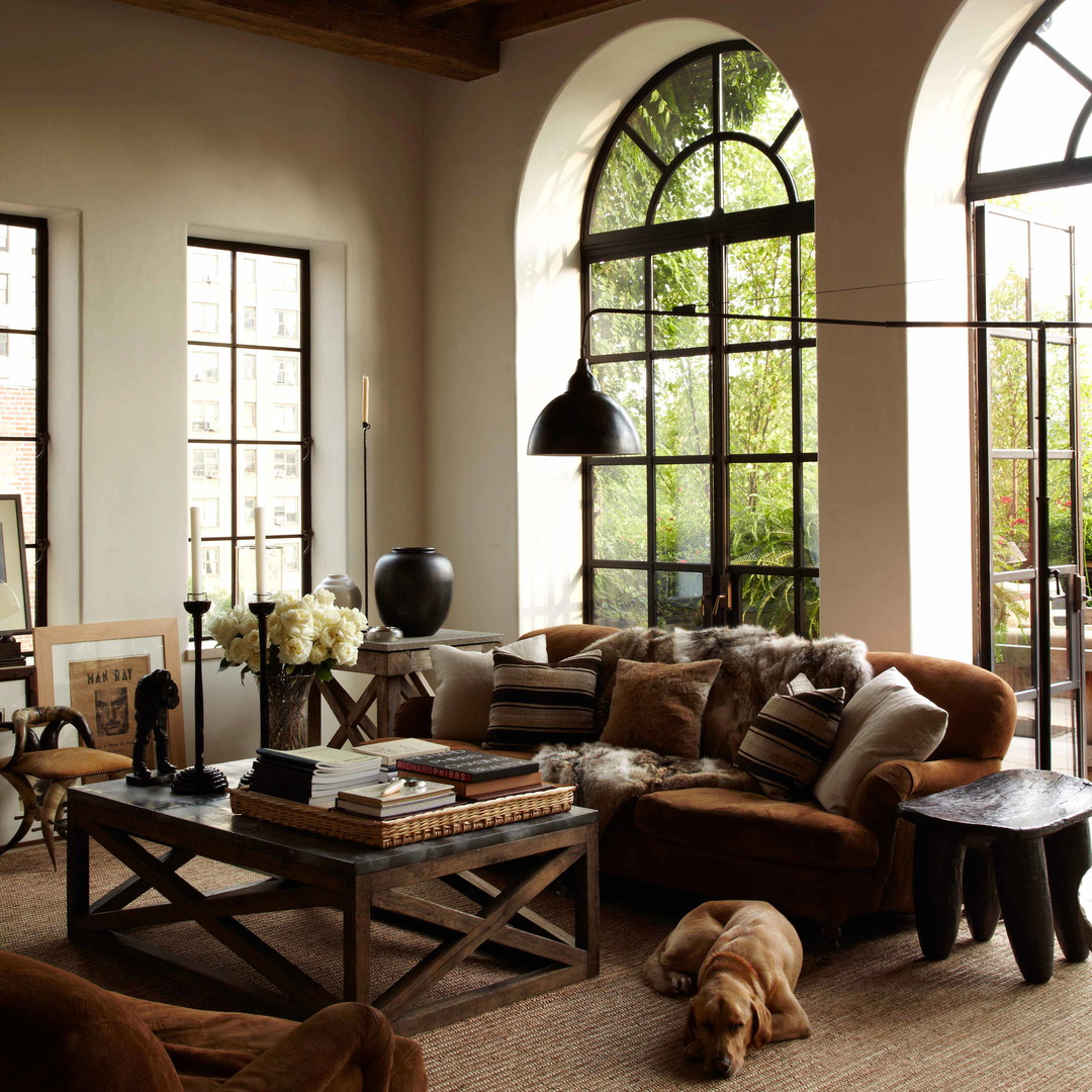 a living room filled with furniture and large windows