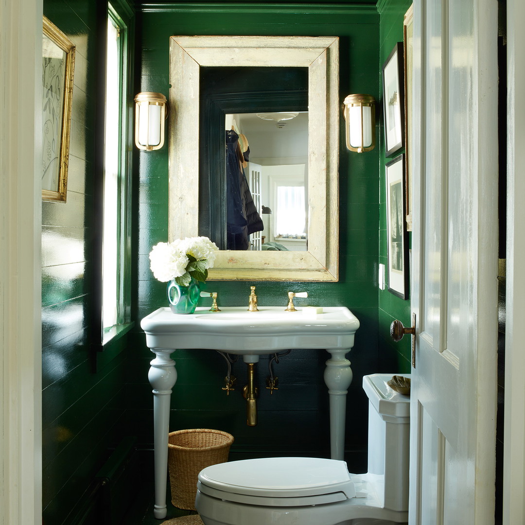 a bathroom with green walls and a white toilet