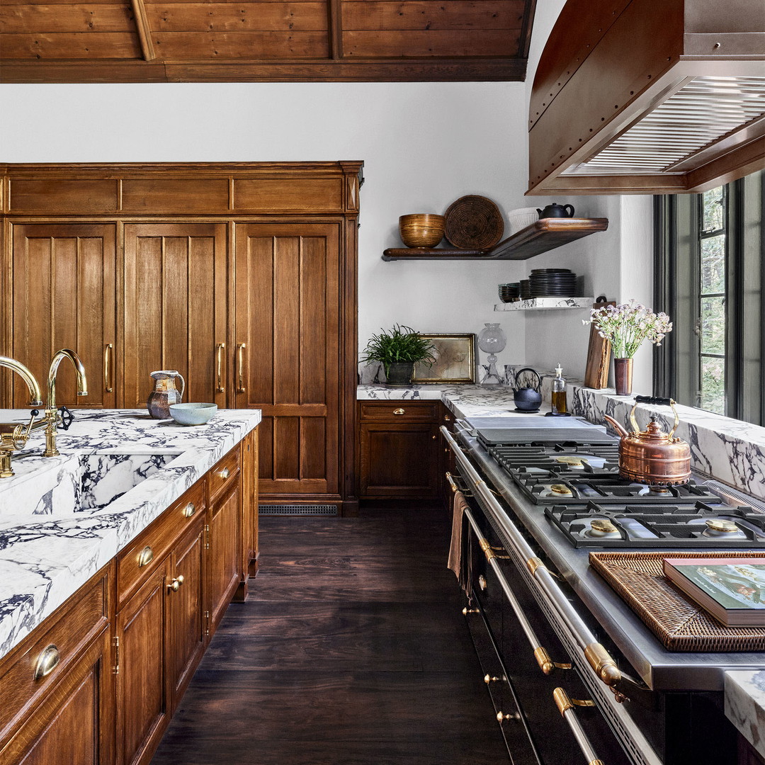 a kitchen with wooden cabinets and marble counter tops