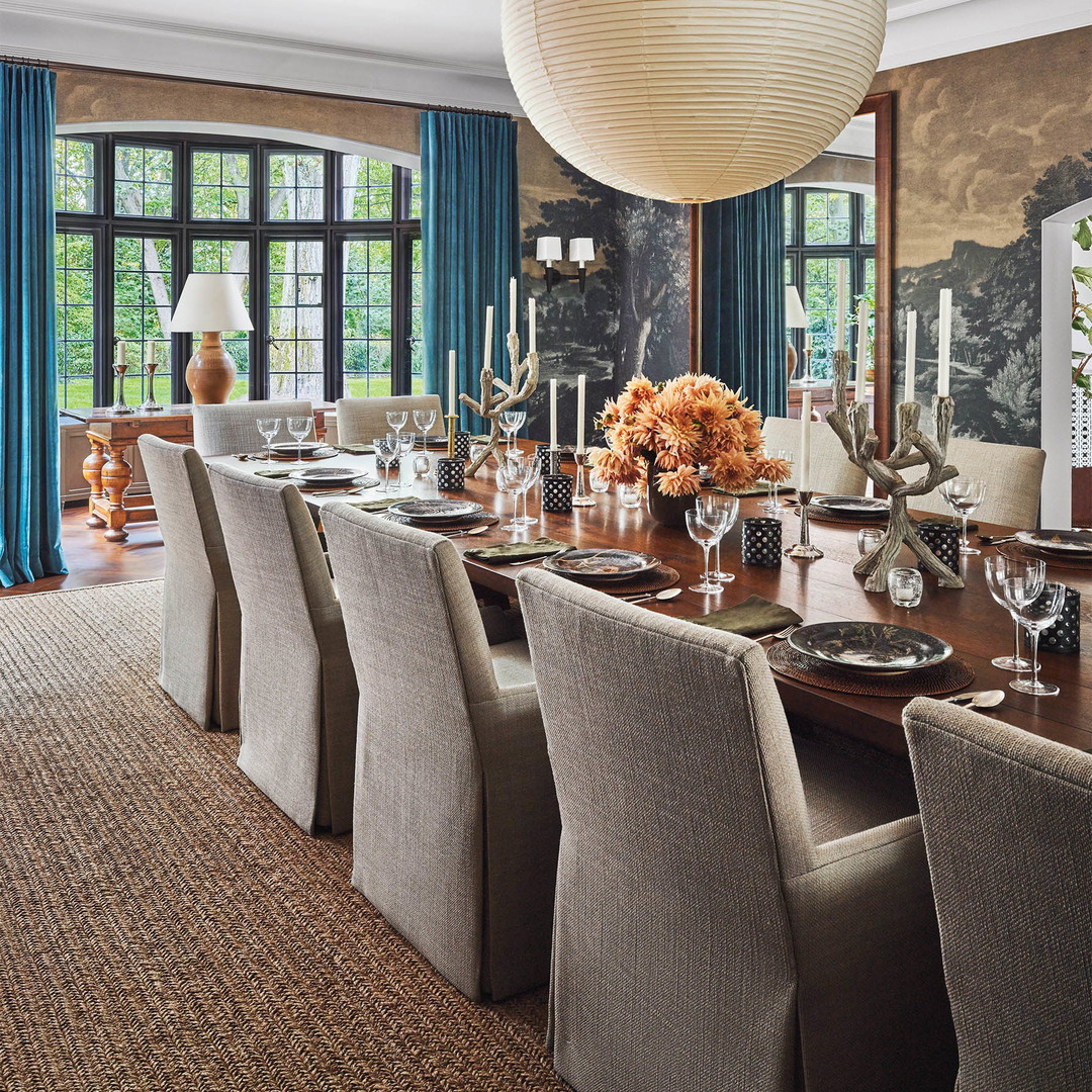 a dining room with a large wooden table surrounded by chairs