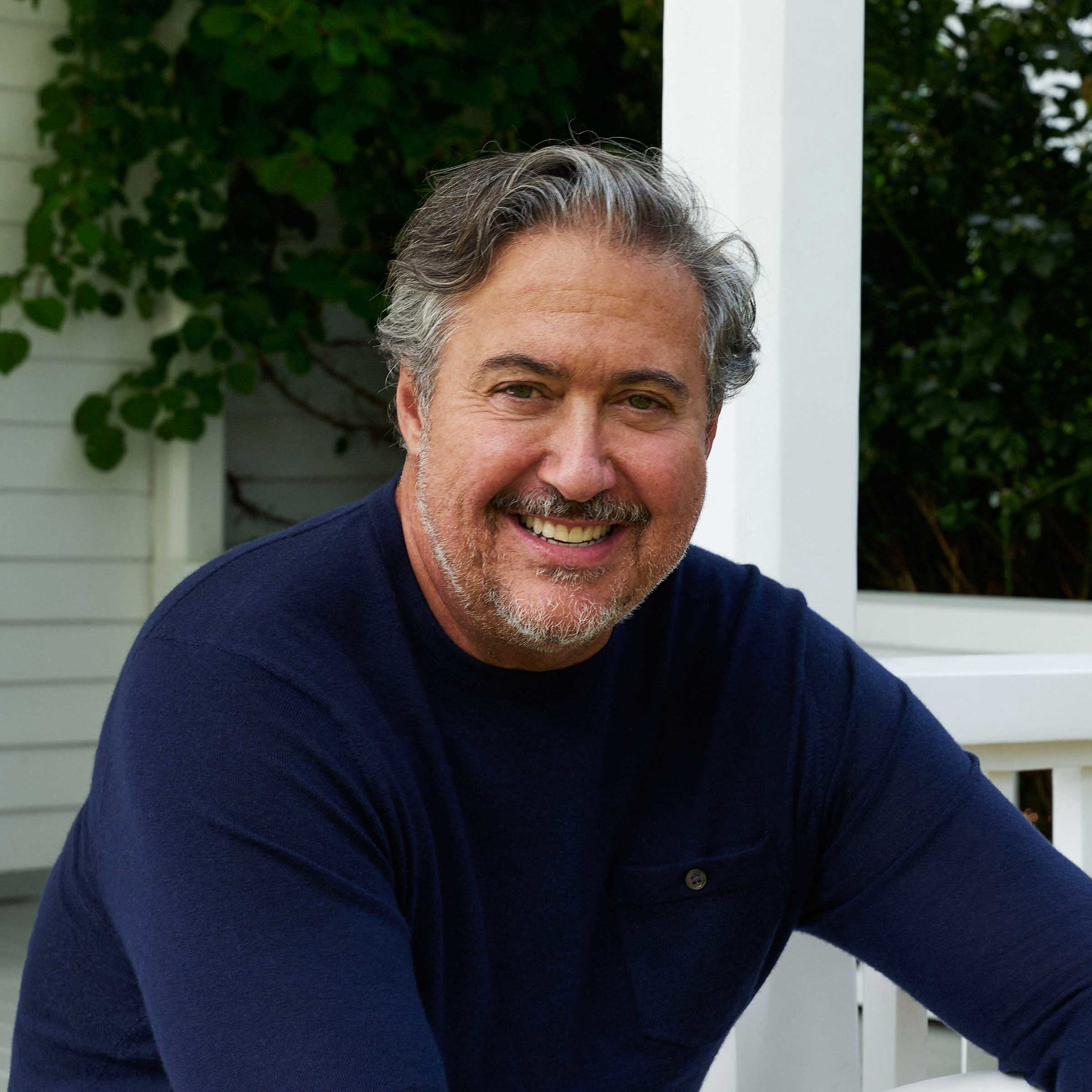 a man sitting on a porch with his legs crossed