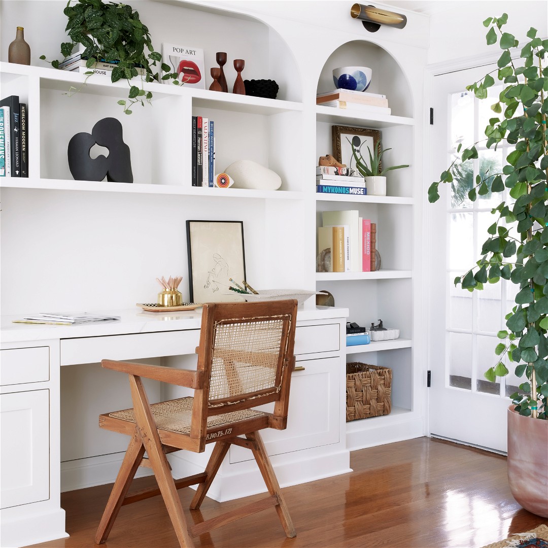 a chair sitting in front of a white book shelf