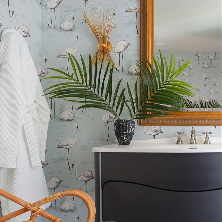 a bathroom with flamingos on the wall and a mirror