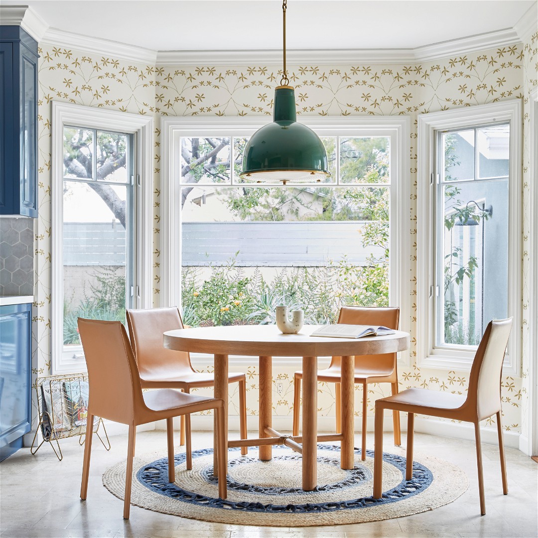 a dining room with a round table surrounded by chairs