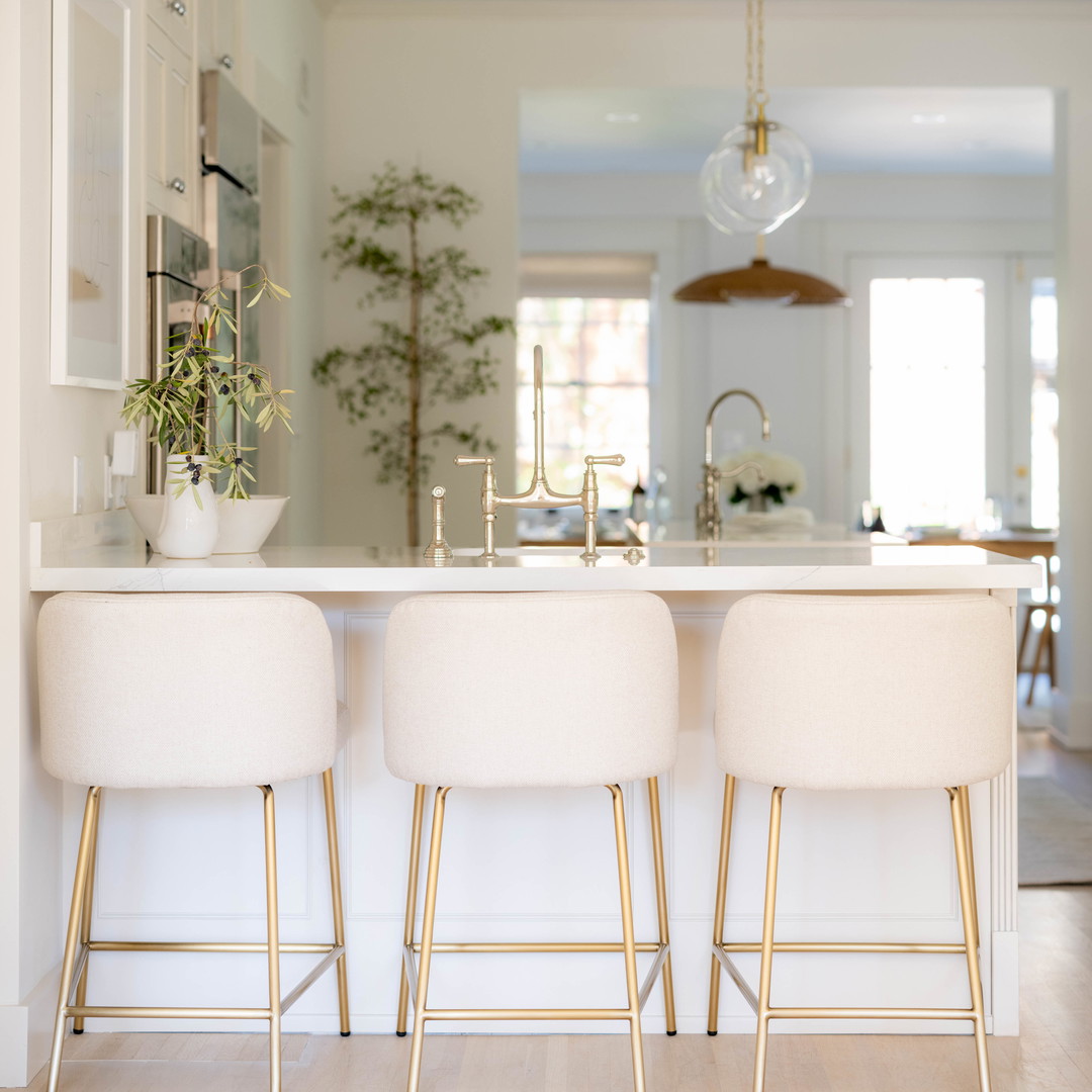 a kitchen with three stools and a sink