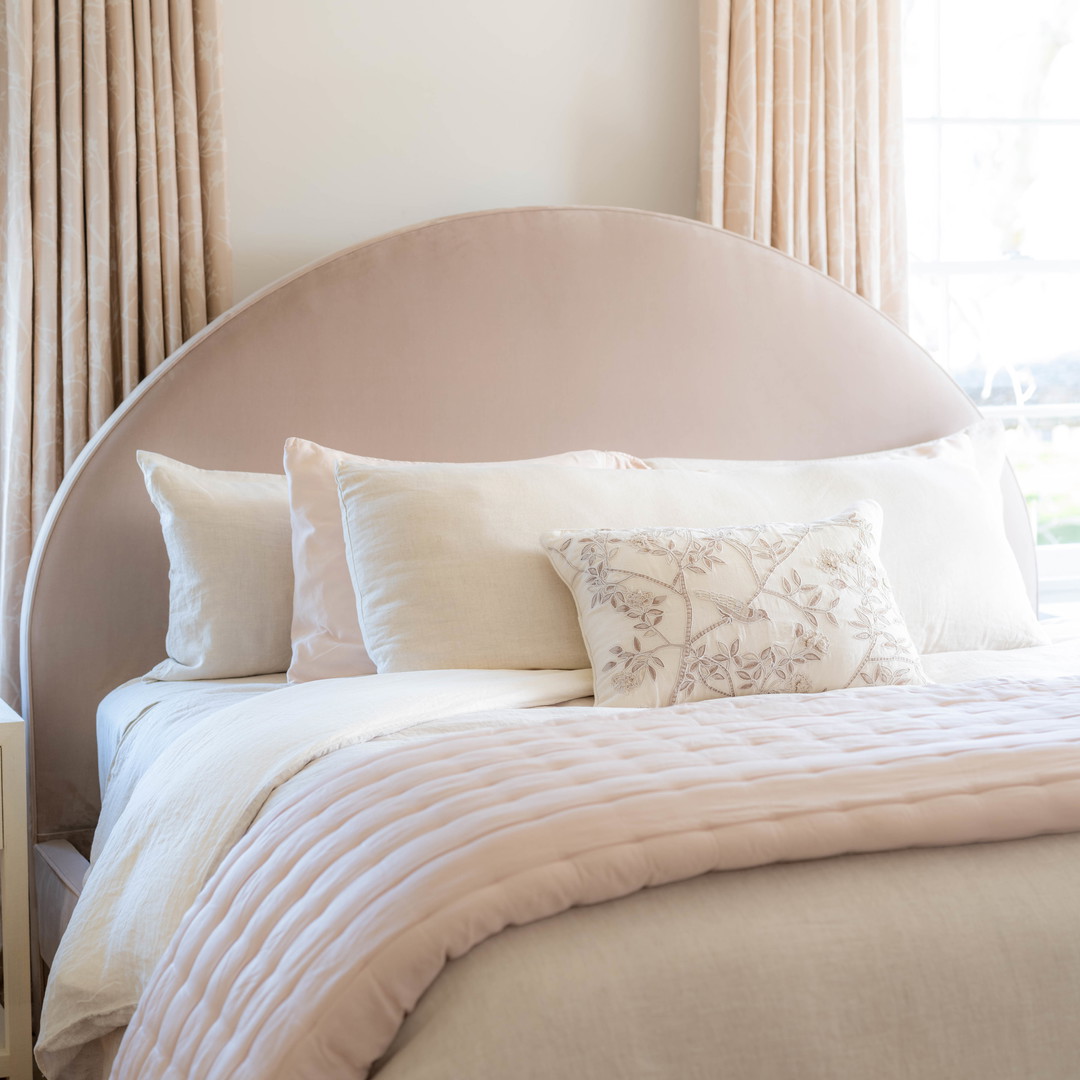 a bed with a white comforter and pillows